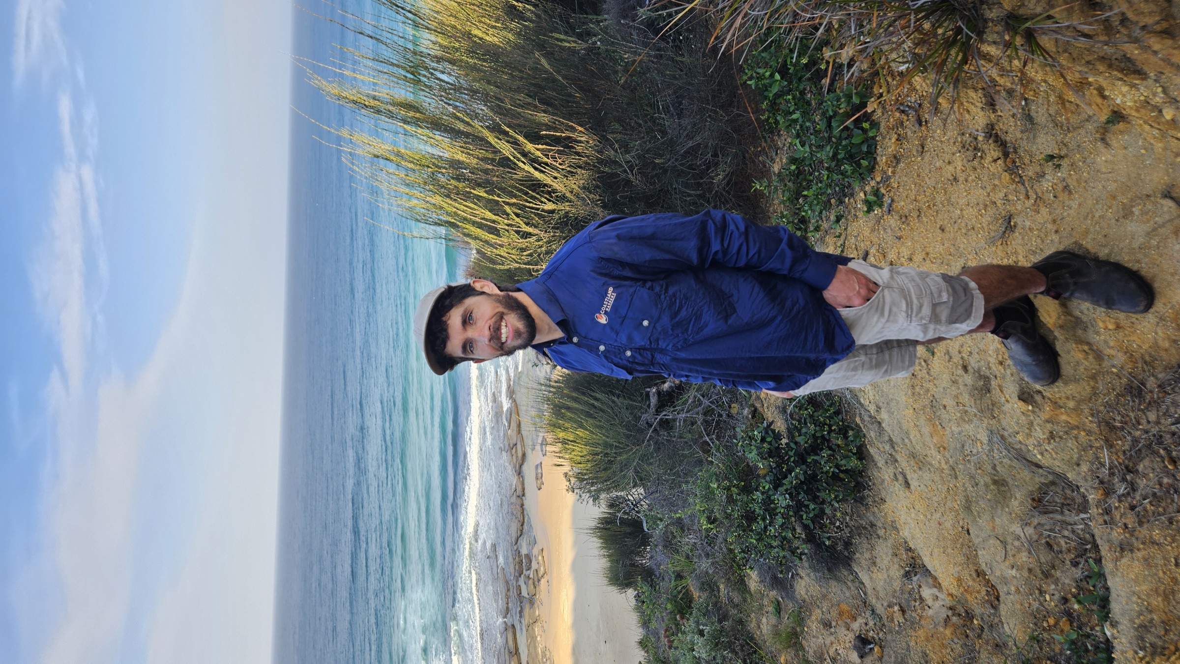Carlos wearing a Coastland Gardens shirt above a South Coast beach